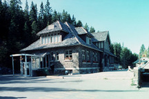 General view of the Upper Hot Springs Bath House showing the its rustic character created by the use of materials which are natural in color and rough in texture and includes, irregularly coursed split-faced limestone walls, wood shakes on the roof, expos; Parcs Canada | Parks Canada, P. Sawyer, 1994.