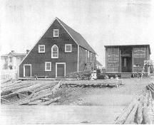 The Mockbeggar Plantation c1920s.  The large building in the center of the photo is referred to as the "fish store".  To the right of that is the barter shop and to the left is the Bradley residence.  ; Department of Tourism, Culture and Recreation 2005