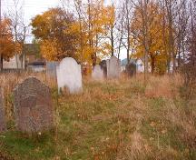 View facing east showing large, eroded headstones, Roman Catholic Parish Cemetery, Harbour Grace, NL.  Photo taken November 1, 2005.; HFNL/ Deborah O'Rielly 2005.