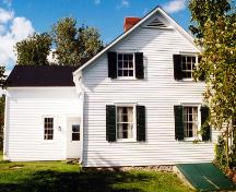 Vue de côté de l'édifice qui illustre les quatre ouvertures fenestrales et de l'aile.; PNB 2003