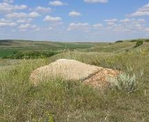 Petroglyphs are incised on the boulder's flat surface, 2004.; Government of Saskatchewan, Marvin Thomas, 2004.