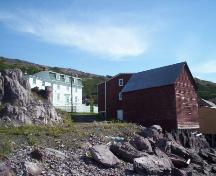 Exterior view of John Quinton Limited property, Red Cliffe, NL, taken from the waterside, showing (left to right) the shop, residence, fish store and salt store.; HFNL/Dale Jarvis 2006