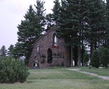 Photo taken from the west side of the Notre-Dame de Lourdes Church, showing the Grotto amongst the trees.; Gérard LeBlanc