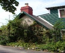Rear view of the Hermitage with thick greenery concealing the stone exterior.  Note the large chimney for such a small structure. Photo taken 2004.; HFNL/ 2006