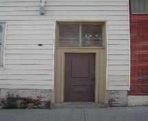 This photograph shows the northern entrance to the building and illustrates that it shares the same setback of its northern neighbor, 2004; City of Saint John
