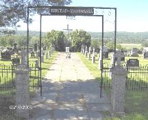 Entrée principale du Cimetière Saint-Basile. "Berceau du Madawaska" est inscrit sur la section supérieure de l'entrée. Il s'agit d'un nom attribué à Saint-Basile, étant le premier endroit qui fut habité dans la région.; Société historique du Madawaska
