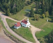 Aerial view of the far west boundary of the Former Mi'kmaq Reserve at Beaumont showing the chapel and its small presbytery, as well as the old and new sections of the cemetery; La Société historique de la Valleé de Memramcook et le Village de Memramcook