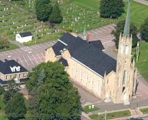 Vue aérienne de l'église Saint-Thomas avec le presbytère à gauche et une partie du cimetière à l'arrière; Memramcook Valley Historical Society