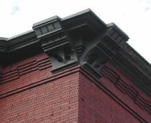 Cette image montre une vue de la corniche supportée par de larges consoles décoratives en bois et ornée d’encorbellements en brique, 2005. ; City of Saint John