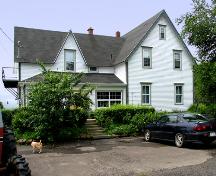 View of east side of farmhouse at 456 Sunset Drive. Gothic Revival influence expressed by bargeboard, steep cross gabled roof and low-pitched veranda roof.; Restigouche Regional Museum, Dalhousie