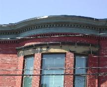 Cette photographie montre la corniche incurvée avec les denticules et frise, 2005; City of Saint John