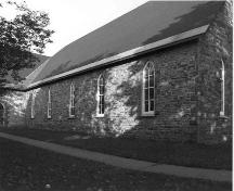 West elevation of nave, showing lancet windows and random rubble masonry of the nave - c. 1983; OHT, 1983