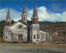 Corner view of the façade and a side of the Church of the Holy Cross, 1983.; Parks Canada Agency/ Agence Parcs Canada, 1983.