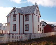 View of Brett Property Municipal Heritage Site, Joe Batt's Arm, showing fence, front and right side of house and outbuilding at rear, 2006/11; L Maynard, HFNL, 2007