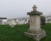 Photo view of St. Andrew’s Anglican Cemetery, Fogo, Fogo Island, NL, with John Slade monument in the forefront, 2007/06/11 ; L Maynard, HFNL, 2007