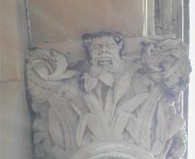 This photograph shows a capital with a gargoyle spitting out coins, 2005; City of Saint John