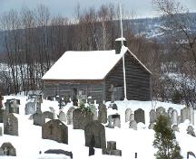 View of the Alexis Cyr House and part of the St-Basile Cemetery in winter.; Madawaska Historical Society