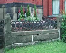This image shows the highly ornate stone and cast iron fence that exhibits a circular and floral design that reflects the pattern specifically designed for the Girl Guide cookies, 2005.; City of Saint John