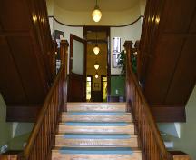 View of double-scissor wooden staircases in entrance of the Memorial Hall, Carman 2005; Historic Resources Branch, Manitoba Culture, Heritage, Tourism and Sport, 2005