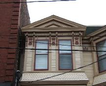 This photograph shows the single-storey upper bay window crowned by a bracketed pediment, and illustrates the decorative frieze of the cornice, 2005; City of Saint John