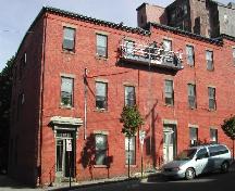 This photograph shows the contextual view of the building, including the roof-line cornice with dentils the other two buildings to the east, 2004; City of Saint John