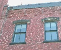 This photograph shows the cornice and upper storey windows, 2005; City of Saint John