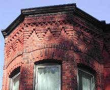 This photograph shows the roof-line cornice with corbel bands and decorative brick work, 2005; City of Saint John