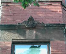 Cette photographie montre la gravure en saillie au-dessus d'un linteau à l'étage inférieur, 2005; City of Saint John