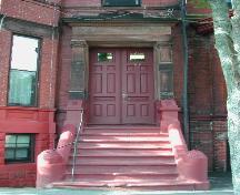 Cette photographie montre l'une des deux entrées principales symétriques avec un grand entablement soutenu par des colonnes ioniques, 2005; City of Saint John