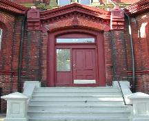 Cette photographie montre l'entrée principale au centre de la façade avant avec des grands pilastres et un entablement pointu, 2005; City of Saint John