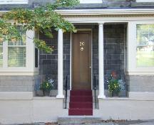 This photograph shows the entrance with dentils and columns that support the porch roof, 2005; City of Saint John