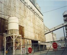 View of the exterior of Elevator 5 B, showing its overall scale, design and materials, which enhance the industrial and port character in the western sector of the Old Port, 1995.; Parks Canada Agency / Agence Parcs Canada, J. Hallé, 1995.