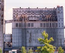 Exterior view of Elevator 5 B, showing the industrial-type fenestration, which is concentrated in the upper and lower sections of the building, 1995.; Parks Canada Agency / Agence Parcs Canada, J. Hallé, 1995.