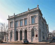 General view of the Old Kingston Post Office, showing the heavily rusticated and vermiculated stonework at ground level with smoother ashlar masonry above, round-arched openings, and a triple-arched recessed entrance.; Parks Canada Agency / Agence Parcs Canada.
