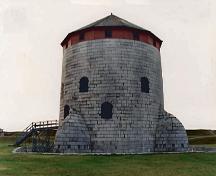 Vue de l'extérieur de la tour Martello située au lieu historique national du Canada des Édifices-de-Point-Frederick, 1993.; Department of National Defence / Ministère de la Défense nationale, 1993.