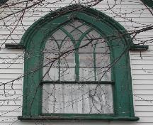 This image provides a view of the Gothic arch window in the central gable with decorative wood tracery and label hood moulding with stops, 2005; City of Saint John