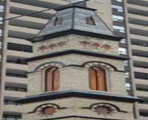 Of note are the patterned mansard roof, the decorative drip mouldings and the round-arched windows.; Martina Braunstein, 2007.