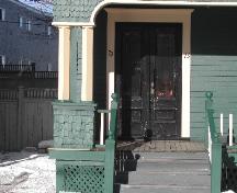 This photograph shows the entrance and the shingled bases of the square pilasters, 2005; City of Saint John