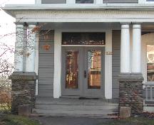 This image provides a view of the entrance including the stained glass transom window over paired wood doors with glass panels, 2006; City of Saint John