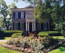 View of the exterior of McQuesten House / Whitehern, showing its five-bay symmetrically organized façade with evenly spaced large, multi-pane sash windows, and its central entry door.; Parks Canada Agency / Agence Parcs Canada.