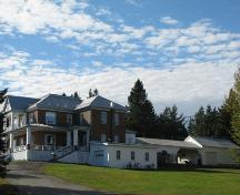 Photo prise en angle, on voit le presbytère ainsi qu'une ancienne remise pour voiture à chevaux; Madawaska Planning Commission