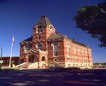 General view of Fredericton City Hall, showing its polychromatic masonry detailing created by stone voussoirs over openings.; Parks Canada Agency / Agence Parcs Canada.
