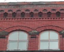 Cette photographie montre la corniche et les fenêtres à arc en plein cintre de l'étage supérieur, 2005; City of Saint John