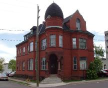The Peters House, now the YWCA of Moncton, sits on the corner of Highfield Street and Campbell Street. Its most striking features are the pink sandstone, the 'beehive' turret and a parapet that emulates Peters' own brass plate designs.; Moncton Museum