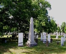 Old Burial Ground section near George Street gate showing fenced tombstones and landscape; City of Fredericton