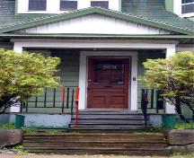 Cette image montre le portique avec un fronton et une porte en panneaux de bois avec une vitre; City of Saint John