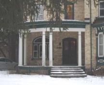 Curved front porch supported by columns and second floor veranda, 2007.; Kayla Jonas, 2007.