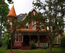 This photograph shows the primary façade of the building, the asymmetrical massing, the large gable and the rounded tower with conical roof, 2007; City of Saint John