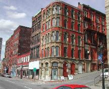 Photograph of the building and its relationship with the neighbouring buildings. The photograph also presents Water Street and the steep slope of Princess Street, 2004.; City of Saint John