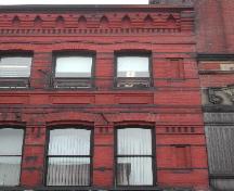 This photograph shows the roof-line cornice and distinguished corbel bands, 2004; City of Saint John